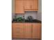 Convenient wet bar with wood cabinets, granite counters and a decorative tile backsplash at 3079 Landmark Blvd # 1608, Palm Harbor, FL 34684