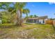 Backyard view shows the rear of the home, sunroom, and the backyard's fence line at 3123 Laird Dr, New Port Richey, FL 34655