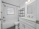 Bathroom featuring a tub with a shower, vanity, and white tile walls at 3123 Laird Dr, New Port Richey, FL 34655