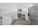 Bright kitchen featuring stainless steel appliances, white cabinets and wood-look flooring at 3123 Laird Dr, New Port Richey, FL 34655