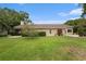 Expansive backyard features lush grass, mature trees, and a view of the home's screened-in patio at 3268 Tanglewood Trl, Palm Harbor, FL 34685