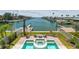Stunning aerial view of backyard pool, waterfront canal, and dock, creating an idyllic setting for relaxation and recreation at 344 Capri Blvd, Treasure Island, FL 33706