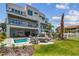 Spacious backyard features a pool, spa, fire pit with lounge chairs, and a spiral staircase to a balcony at 344 Capri Blvd, Treasure Island, FL 33706
