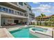 Inviting backyard with a pool, spa, outdoor kitchen, and a spiral staircase to a second-story balcony at 344 Capri Blvd, Treasure Island, FL 33706