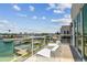 Enjoy serene waterfront views from this balcony with clear railings, modern outdoor seating, and a light wood floor at 344 Capri Blvd, Treasure Island, FL 33706