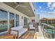 A luxurious covered balcony features stylish seating, a ceiling fan, and water views, perfect for outdoor relaxation and entertaining at 344 Capri Blvd, Treasure Island, FL 33706