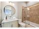 Bright bathroom with wood vanity, gold fixtures, modern mirror, and tiled shower at 344 Capri Blvd, Treasure Island, FL 33706