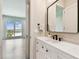 Modern bathroom with a white vanity, dark fixtures, and views to the bedroom and water at 344 Capri Blvd, Treasure Island, FL 33706