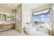 Bright bathroom with a soaking tub by a large window and a marble shower, offering luxury and relaxation with canal views at 344 Capri Blvd, Treasure Island, FL 33706