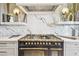 Chef's kitchen featuring a high-end range, custom hood, and marble backsplash at 344 Capri Blvd, Treasure Island, FL 33706