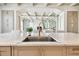 Bright kitchen island with marble countertops and stainless steel sink, open to the living room at 344 Capri Blvd, Treasure Island, FL 33706