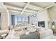 Bright, open living room with a fireplace, white furniture, beamed ceilings, and serene water views at 344 Capri Blvd, Treasure Island, FL 33706