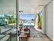 Stylish outdoor living area with covered seating, pool, and water views from the patio at 344 Capri Blvd, Treasure Island, FL 33706