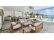 Elegant covered outdoor living area with pool, water views, and outdoor kitchen at 344 Capri Blvd, Treasure Island, FL 33706