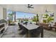 Luxurious covered patio featuring a dining area, lounge seating, and a spiral staircase overlooking a canal and pool at 344 Capri Blvd, Treasure Island, FL 33706