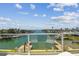 Breathtaking waterfront view from the balcony features palm trees, boat docks, and beautiful blue water at 344 Capri Blvd, Treasure Island, FL 33706