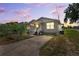 Exterior view of cozy home with charming porch and fresh landscaping; the scene is beautifully lit by the sunset at 3801 Carroway St, Tampa, FL 33619