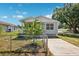 Charming single-story home featuring a fenced yard and inviting front porch, bathed in natural light on a sunny day at 3801 Carroway St, Tampa, FL 33619