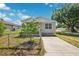 Exterior view with fenced yard, mature tree, and concrete driveway, offering a suburban setting at 3801 Carroway St, Tampa, FL 33619