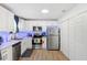 Bright kitchen with stainless steel appliances, white cabinets, hardwood floors, and modern lighting at 3801 Carroway St, Tampa, FL 33619
