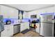 Modern kitchen featuring white cabinets, wood floors, sleek appliances, and ample natural light, designed for convenience and style at 3801 Carroway St, Tampa, FL 33619