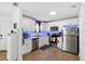 Modern white kitchen featuring stainless steel appliances, wood flooring, and sleek countertops, perfect for culinary enthusiasts at 3801 Carroway St, Tampa, FL 33619