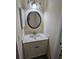 Bathroom features a marble vanity with a sink, and a round framed mirror at 38225 Ironwood Pl # 38225, Zephyrhills, FL 33542