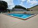 Community pool surrounded by a white fence, lounge chairs, and clear blue water for residents to enjoy at 38225 Ironwood Pl # 38225, Zephyrhills, FL 33542