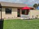 Cozy single-story home with a well-manicured lawn, decorative white picket fence, and a bright red umbrella at 38225 Ironwood Pl # 38225, Zephyrhills, FL 33542
