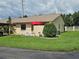 Charming single-story home with a well-manicured lawn, white picket fence, and a decorative red umbrella at 38225 Ironwood Pl # 38225, Zephyrhills, FL 33542