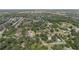 Aerial view of a neighborhood with lush trees and residential homes under a bright sky at 4815 N Falkenburg Rd, Tampa, FL 33610