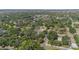 Aerial view of a neighborhood featuring mature trees and residential homes with a swimming pool under a sunny sky at 4815 N Falkenburg Rd, Tampa, FL 33610