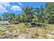 View of the property's cleared backyard, which contains discarded construction materials and trash at 4815 N Falkenburg Rd, Tampa, FL 33610