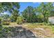 Large, partially cleared backyard surrounded by mature trees and a vintage camper on a sunny day at 4815 N Falkenburg Rd, Tampa, FL 33610
