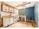 Interior shot of a kitchen featuring aged cabinets, outdated appliances, and worn flooring at 4815 N Falkenburg Rd, Tampa, FL 33610