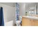 Bright bathroom featuring a tub, sink with wood cabinets, and a shower with a blue curtain at 5000 Culbreath Key Way # 8-319, Tampa, FL 33611