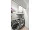 Cozy laundry room featuring gray LG washer and dryer, water heater, and storage shelves at 5000 Culbreath Key Way # 8-319, Tampa, FL 33611