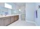 Elegant bathroom featuring double sinks, modern cabinetry, and a glass enclosed shower at 5732 Stockport St, Riverview, FL 33578