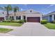 Charming one-story home with well-manicured landscaping, a brown garage door and a concrete driveway at 5732 Stockport St, Riverview, FL 33578
