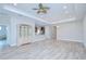 Spacious living room featuring wood-look tile flooring, tray ceiling, and modern light fixtures at 5732 Stockport St, Riverview, FL 33578