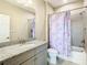 Well-lit bathroom with granite counters, gray cabinets, and shower-tub combination with unicorn shower curtain at 5807 Circa Fishhawk Blvd, Lithia, FL 33547