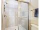 Close-up of tiled shower with glass door and tiled shower caddy at 5807 Circa Fishhawk Blvd, Lithia, FL 33547
