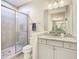 Elegant bathroom with granite counters, gray cabinets and glass-enclosed shower, plus a large mirror at 5807 Circa Fishhawk Blvd, Lithia, FL 33547