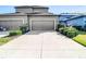 Wide driveway leading to a home with two garage doors surrounded by green landscaping at 5807 Circa Fishhawk Blvd, Lithia, FL 33547