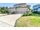 Two car garage with a concrete driveway, and beautiful landscaping in the front at 5807 Circa Fishhawk Blvd, Lithia, FL 33547