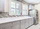 Modern kitchen with stainless steel refrigerator, light countertops, and gray cabinets at 5807 Circa Fishhawk Blvd, Lithia, FL 33547