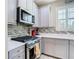Kitchen featuring gray cabinets, stainless steel appliances, a tile backsplash, and quartz countertops at 5807 Circa Fishhawk Blvd, Lithia, FL 33547