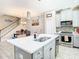 Bright kitchen island with modern lighting, a stainless steel sink, and seating, open to dining area at 5807 Circa Fishhawk Blvd, Lithia, FL 33547