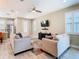 Bright living room featuring tile floors, stylish sofas, a ceiling fan, and modern entertainment center at 5807 Circa Fishhawk Blvd, Lithia, FL 33547