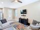 Open living area with hardwood floors, comfortable seating, and a mounted TV for entertainment at 5807 Circa Fishhawk Blvd, Lithia, FL 33547